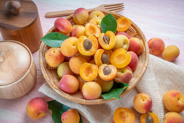 Apricot fruit on bamboo basket on wooden table, fresh Apricot with leaf.