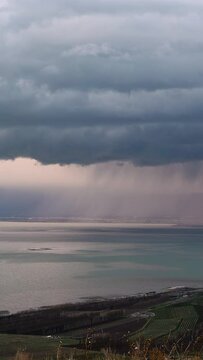 Heavy rainstorm moving over Utah Lake with thick dark clouds over the water in Utah Valley.