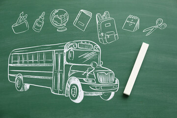 Drawing of school bus with stationery and chalk on blackboard
