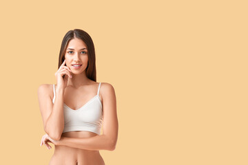 Young tanned woman on beige background