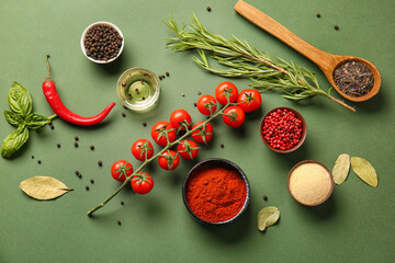 Composition with different spices, vegetables and herbs on green background