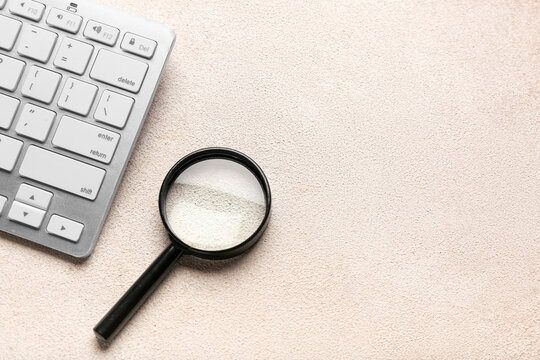 Keyboard and magnifier on light background. Concept of search