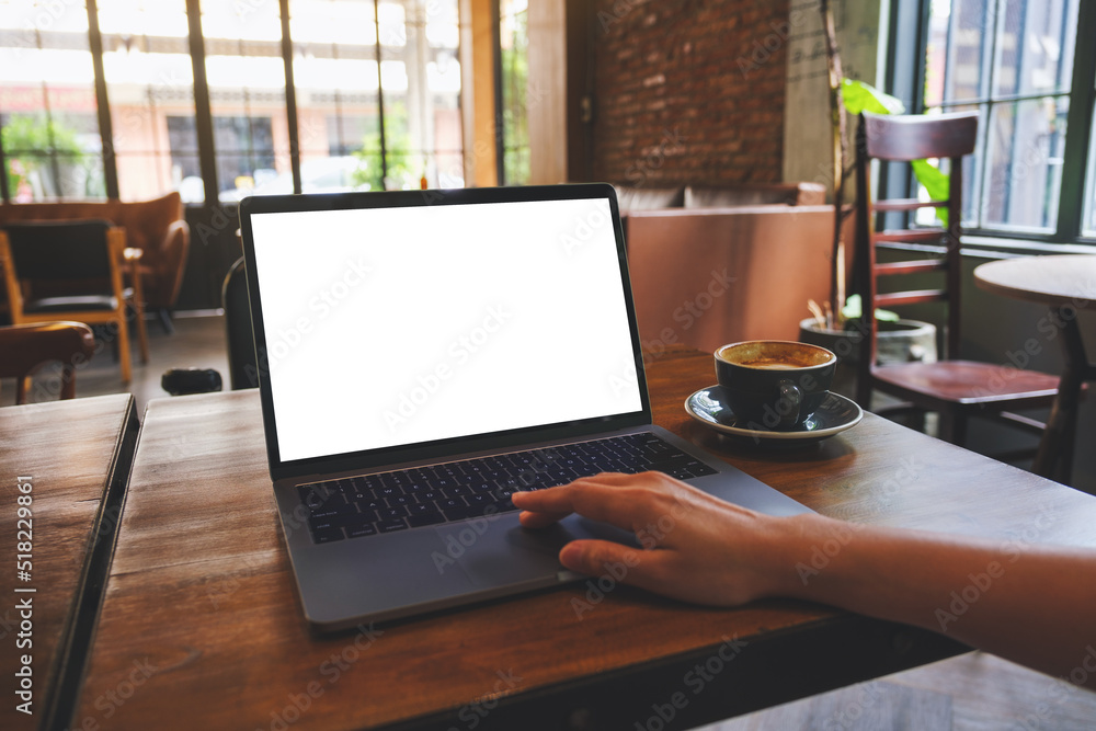 Wall mural mockup image of a woman using and touching on laptop computer touchpad with blank white desktop scre