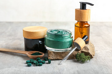 Composition with cosmetics and spirulina pills on light background