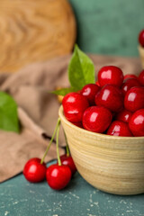 Bowl of sweet cherries on color background, closeup