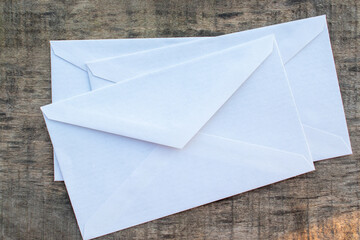 White envelopes on old gray wooden table background. Top view, flat lay, mock up, copy space	