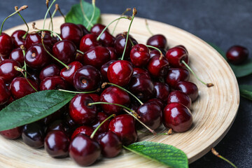 Plate with ripe cherries on table, closeup