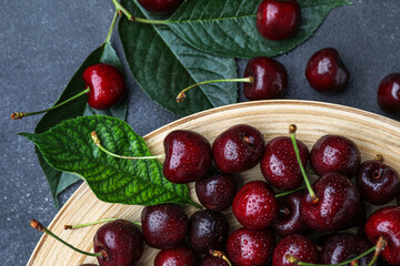 Fototapeta na wymiar Plate with ripe cherries on table, closeup