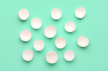 Many halves of egg shells on color background