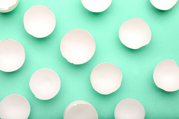 Many halves of egg shells on color background