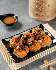Dimsum with Japanese Mentai Sauce. Served on plate and chopstick. Close up and selective focus image.

