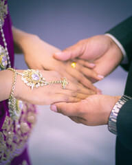Fototapeta premium Newlyweds hands, groom holding bride's hands. Concept of the beginning of the new journey.