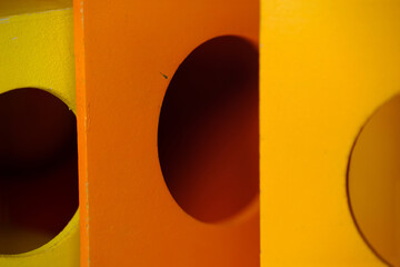 Children's orange and yellow wooden toy blocks with circular windows cut into them