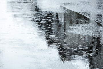 raindrops rippling in puddles. street road during rainy day.