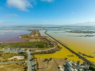 Aerial panorama view of Alviso district in San Jose California with rundown buildings colorful orange, yellow salt marshes in the Bay Area