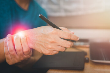 Close up man using laptop suffering from wrist pain sitting on work room, health problem and people concept