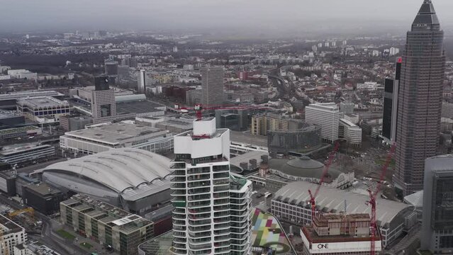 Large cranes on construction site of tall modern buildings. City scape with exhibition centre area. Frankfurt am Main, Germany