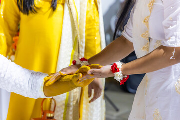 Indian pre wedding haldi turmeric ceremony groom's hands close uup