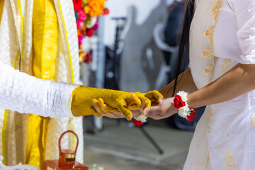 Indian pre wedding haldi turmeric ceremony groom's hands close uup