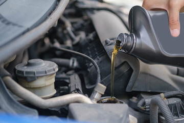 beautiful girl Refueling and pouring oil quality into the engine motor car Transmission and Maintenance Gear .Energy fuel concept. car maintenance