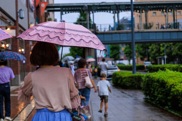 Obraz na płótnie Canvas 雨の日に傘をさして歩く人々