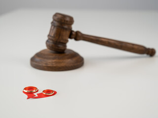 Judicial gavel broken heart and wedding rings.