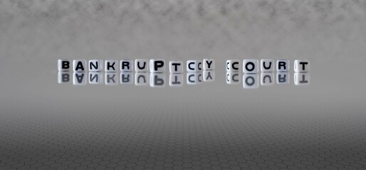 bankruptcy court word or concept represented by black and white letter cubes on a grey horizon...