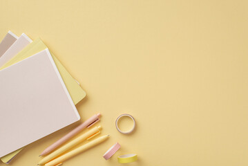 Back to school concept. Top view photo of school supplies diaries adhesive tape and pens on isolated pastel yellow background with copyspace