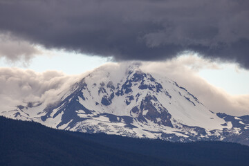 Fototapeta na wymiar Snow covered mountain with heavy grey clouds