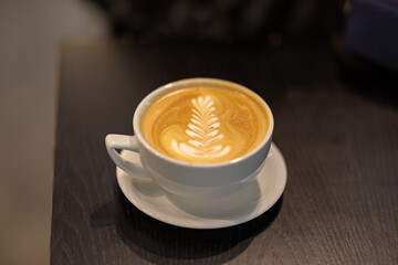 Cup of coffee with creative foam leaf