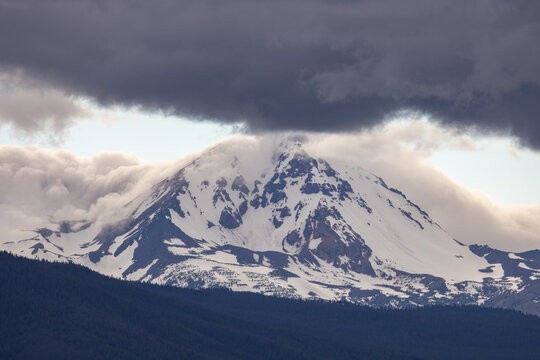 Snow covered mountain with heavy grey clouds