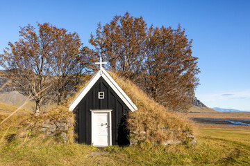 Old wooden black church in southern Iceland. Traditional style building with turf sides and roof, which helps to insulate in the cold winters - Powered by Adobe