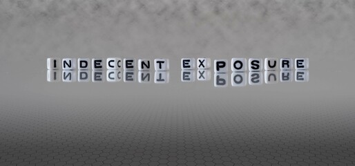 indecent exposure word or concept represented by black and white letter cubes on a grey horizon...