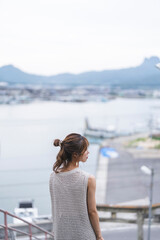 Fototapeta premium 夕暮れの海街を散策する女性