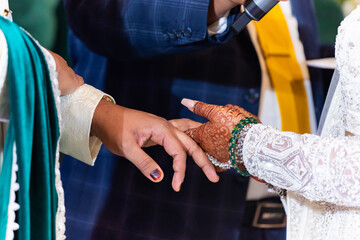 Indian couple's exchanging wedding rings hands close up