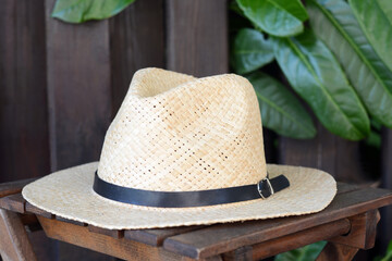 Stylish hat on wooden stool near fence. Beach accessory