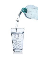 Pouring soda water from bottle into glass on white background