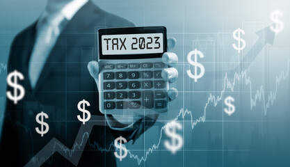 Tax 2023 on calculator. .Businessman hold and show Calculator with word tax 2023. Concept of taxes paid by individuals and corporations such as VAT, income tax and property tax.