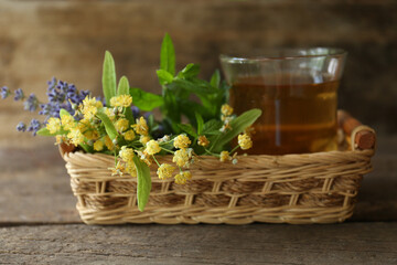 Fototapeta na wymiar Tasty herbal tea, fresh lavender flowers and linden branches on wooden table, closeup