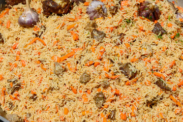 a large cauldron with Uzbek pilaf macro photo
