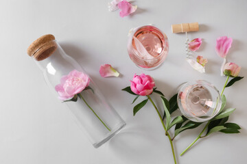 Flat lay composition with rose wine and beautiful pink peonies on white background