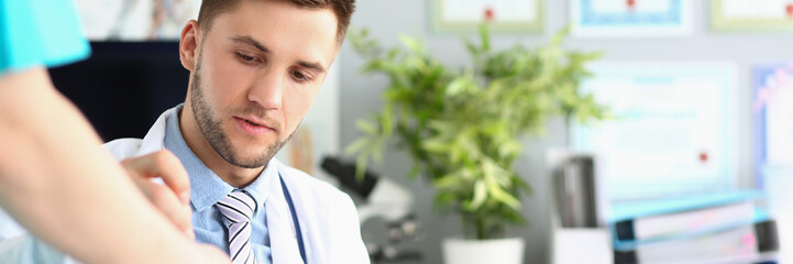 Man doctor in personal cabinet put signature of medical paper