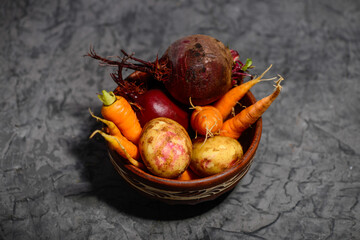 fresh vegetables beetroot and carrot in a clay plate
