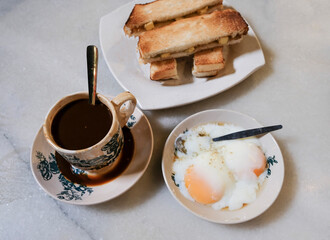 Breakfast in Malaysian Chinatown. Hainanese Breakfast. Toasted bread with butter and kaya, half...