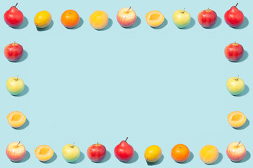 Creative summer frame made of ripe fruits on a mint background.