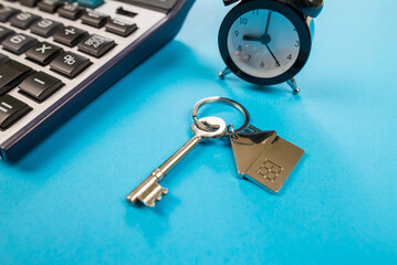 Apartment house key with calculator concept to calculate expenses, loan or insurance with copy space