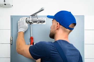 Handyman Installing And Fixing Automatic Door Closer - obrazy, fototapety, plakaty