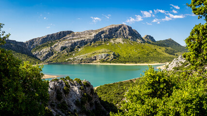 Naklejka na ściany i meble High angle view panorama of Palma de Mallorca drinking water reservoir called Embassament de Cuber with the mountain peaks Puig de Sa Rateta, Puig de Na Franquesa and Puig de L’Ofre in the background.