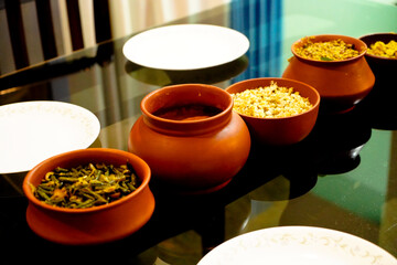 Food items in clay vessels on dining table