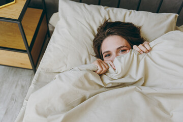 Young woman wear white shirt pajama she lying in bedcover mouth with blanket rest relax spend time...